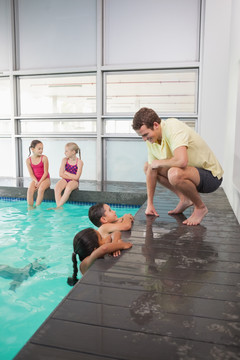 老师教导孩子练习游泳