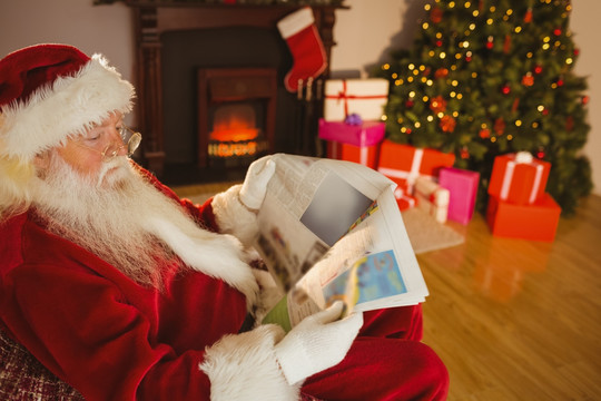 圣诞老人坐在沙发上看报纸
