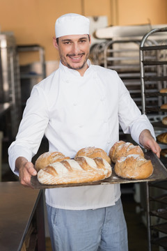 微笑着拿着面包的厨师