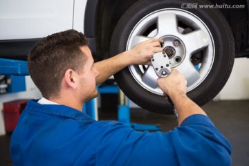 在修汽车轮胎的男修理工