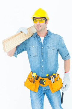 微笑着拿着木板的维修工