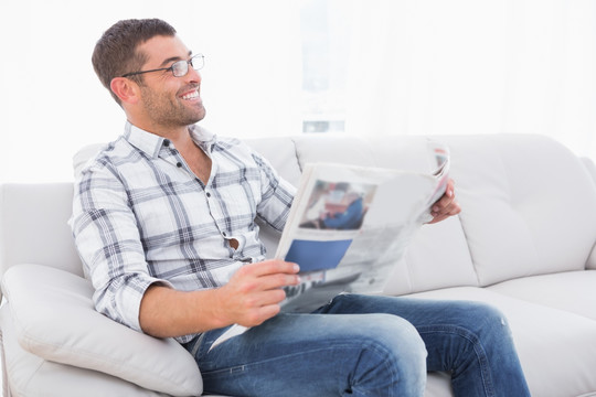 男人在沙发上看一份报纸