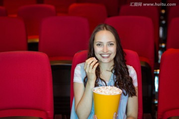 在电影院看电影吃爆米花的女人