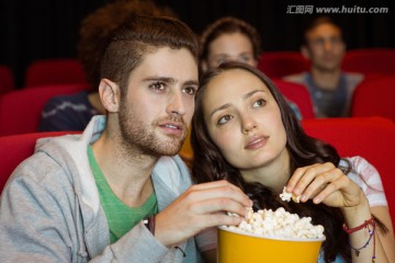 一对年轻夫妇在电影院看电影