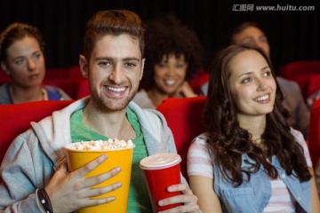 在电影院看电影的年轻夫妇