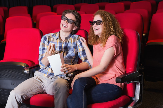 一对年轻夫妇在电影院里看电影