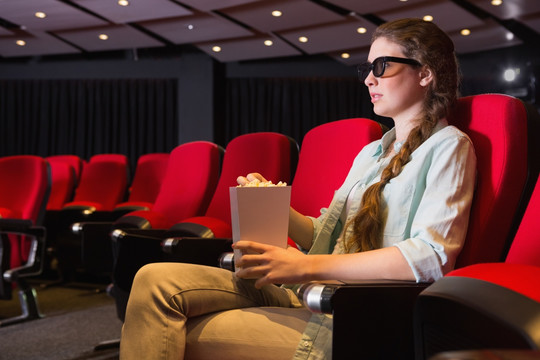 年轻的女人在电影院看3D电影