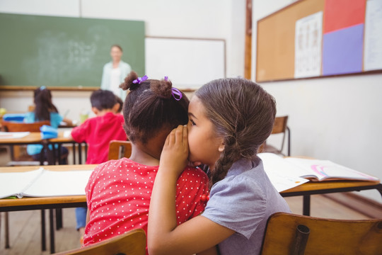 在教室里窃窃私语的小学生