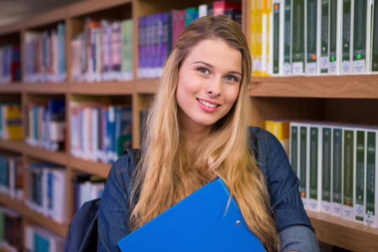 漂亮的女大学生在大学的图书馆里