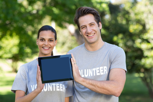 志愿者夫妇展示一台平板电脑