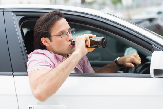 开车喝啤酒的男人