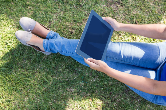 在公园里使用平板电脑的女人