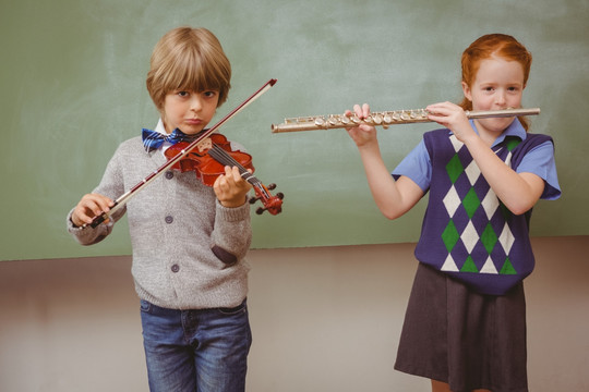在教室里演奏小提琴和长笛的学生