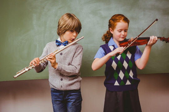 在教室里演奏小提琴和长笛的学生