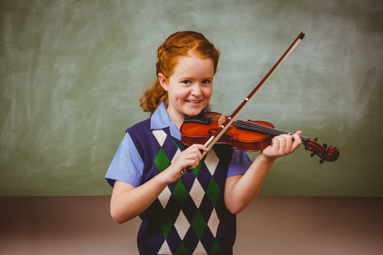 可爱的小女孩在教室里拉小提琴