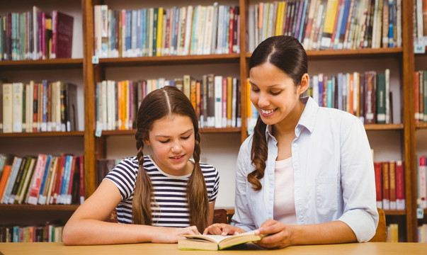女教师和小女孩在图书馆看书