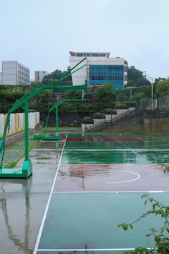 城市里雨后的篮球场的篮球架