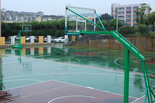 城市里雨后的篮球场的篮球架