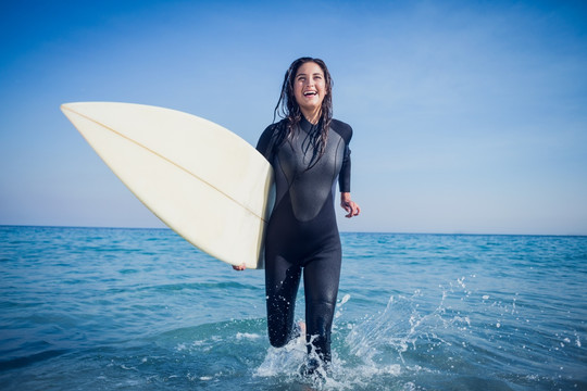 开心的女人拿着冲浪板