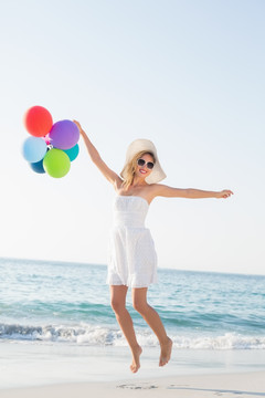 拿着气球泡在海边的女人