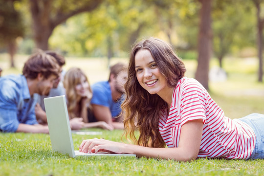 微笑的学生在用笔记本电脑