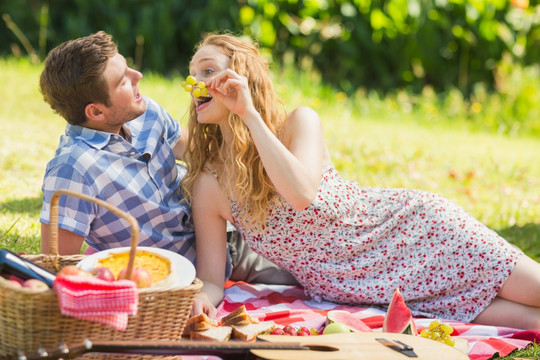一对年轻夫妇在公园里吃葡萄