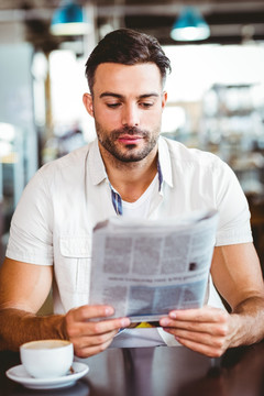 在咖啡馆里看报纸的男人