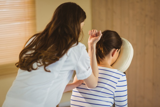 治療師為女人做背部按摩