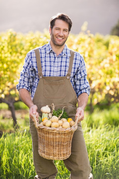 微笑的农夫的拿着一篮土豆