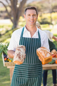 微笑的农民男子拿着面包