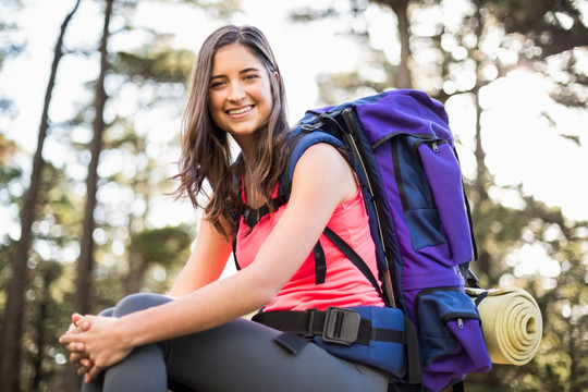 背着登山包坐在岩石上的女人