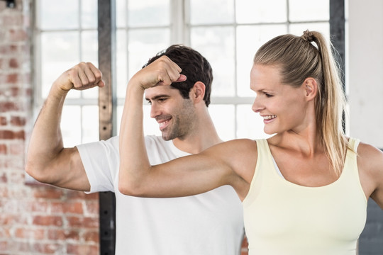 在健身房里展示肌肉的男人和女人