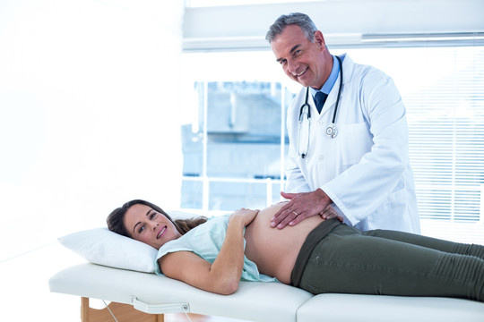 男医生在检查孕妇的肚子