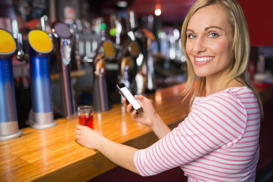 在酒吧使用手机的商务女人