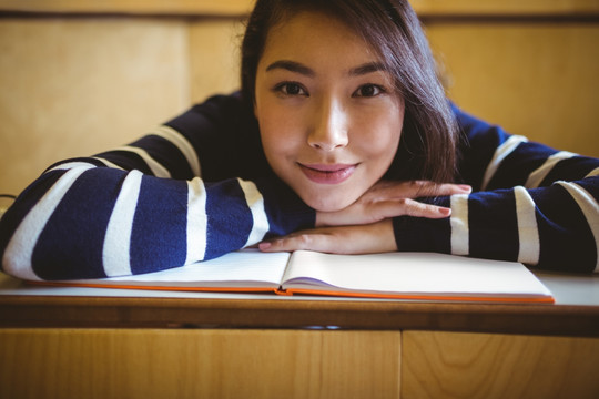 微笑的女学生在大学的演讲厅里