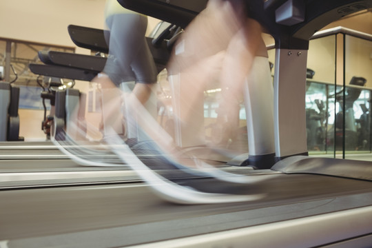在健身房使用跑步机的女人