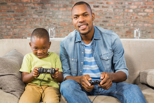 父亲和儿子在客厅里玩电子游戏