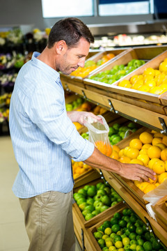 在超市里选水果的男人