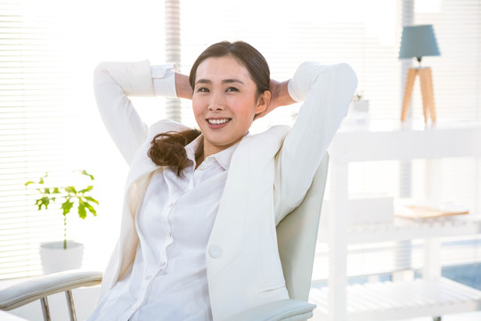 靠坐在椅子上微笑的商務(wù)女人