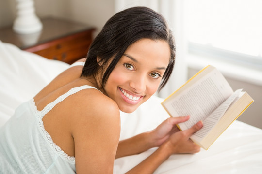 趴在床上看书的女人
