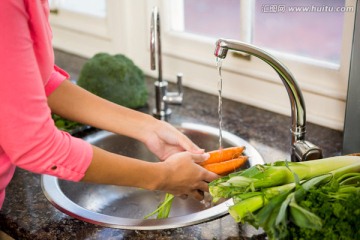 在厨房里洗胡萝卜的女人