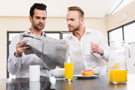 边用早餐的边看报纸的两个男人