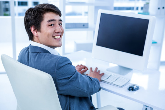 微笑着使用电脑的商务男人