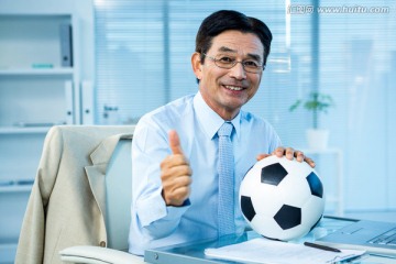 商人抱着足球在办公室里
