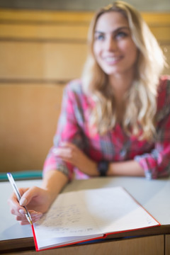 微笑的女大学生在教室里上课