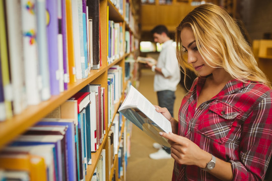 在图书馆里阅读书籍的女大学生