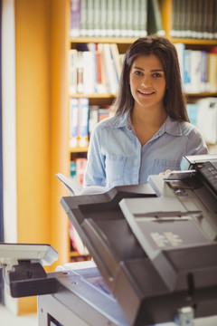 在图书馆里使用复印机的女学生