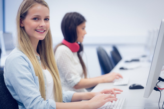 微笑的学生在大学里使用电脑