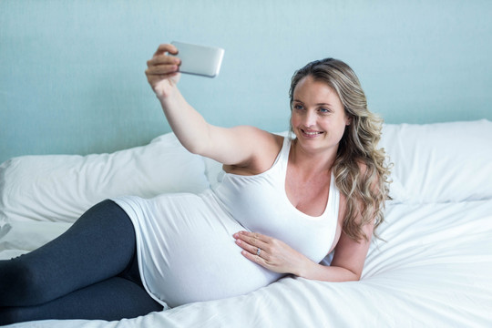 在用手机自拍的孕妇