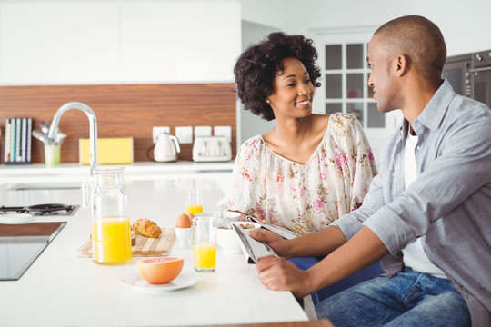 微笑的夫妇在厨房里一起吃早餐